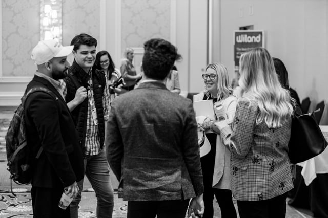 Attendees networking in the hallway outside the sessions