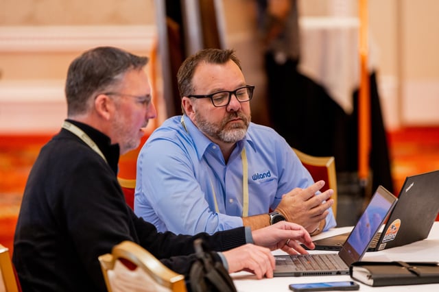 Two attendees meeting one-on-one over a laptop