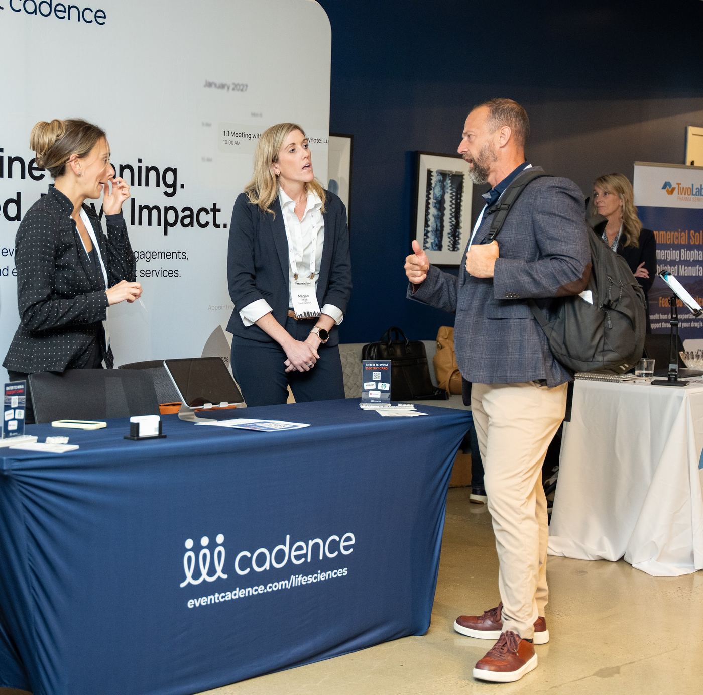 Attendees in conversation with a sponsor at an exhibit table